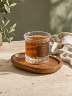 Glass mug with wood sleeve on an oval wood tray