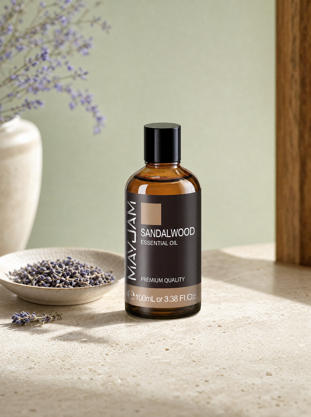 Essential oil bottle beside dried lavender on a stone table