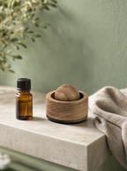 Wood aroma diffuser with essential oil on a stone shelf